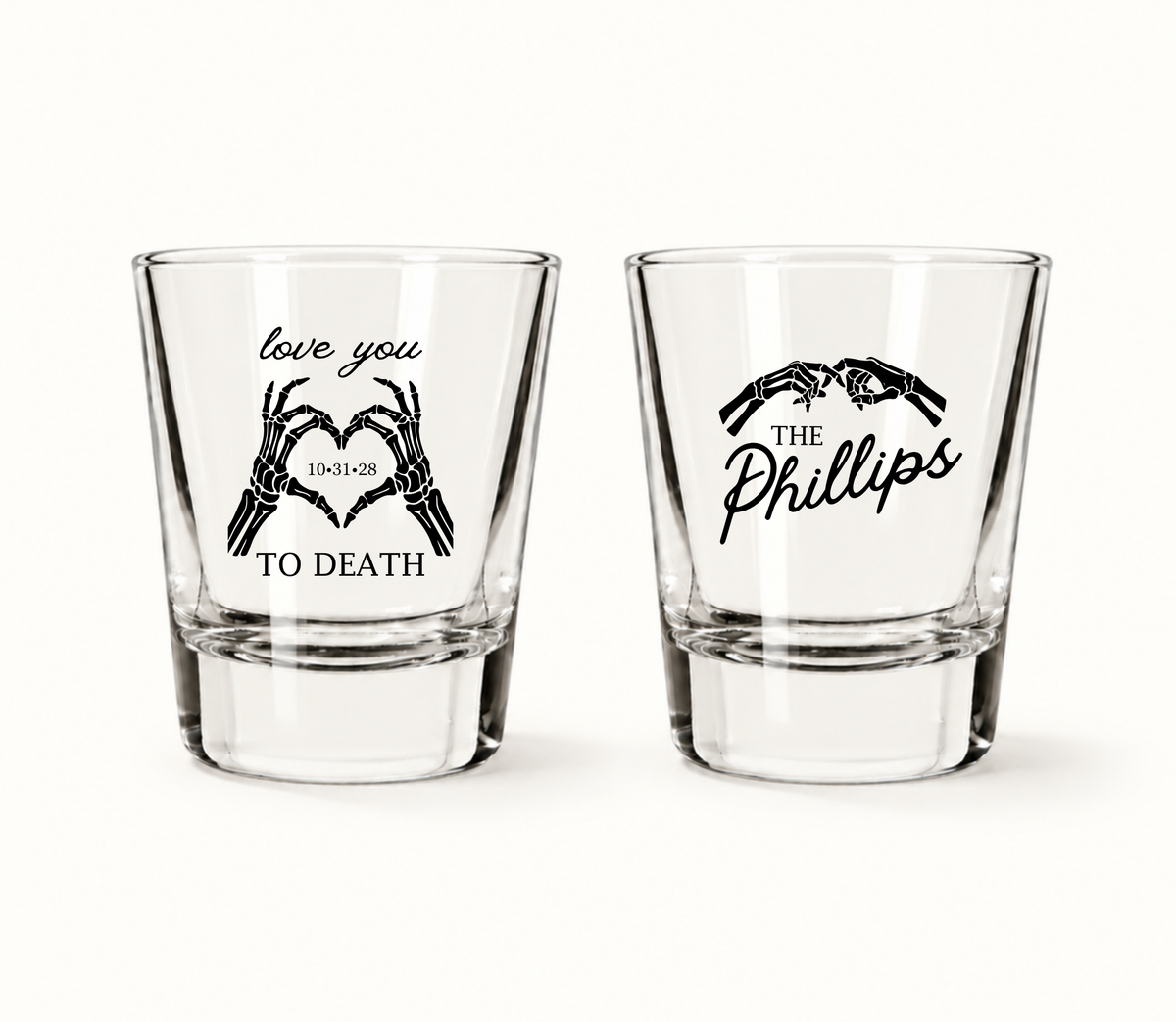 Personalized Love You to Death wedding shot glasses featuring black skeleton hands forming hearts, wedding date 10.31.28, and The Phillips personalized surname design.