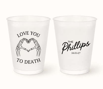 Personalized Love You to Death Halloween wedding frosted cups featuring black skeleton hands forming a heart, The Phillips last name, and wedding date 10.31.27.