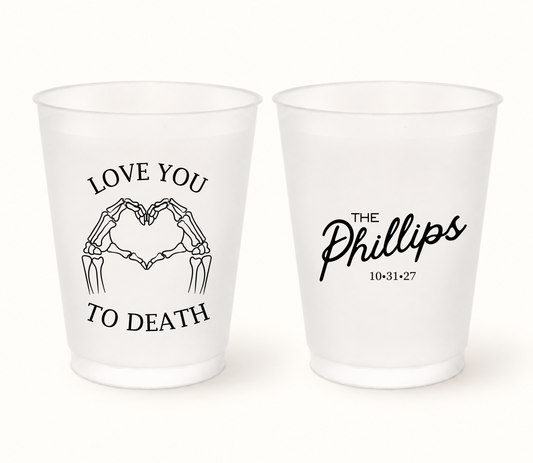 Personalized Love You to Death Halloween wedding frosted cups featuring black skeleton hands forming a heart, The Phillips last name, and wedding date 10.31.27.