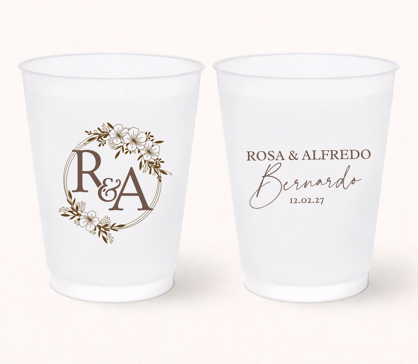 Two white frosted cups with personalized designs on a white background