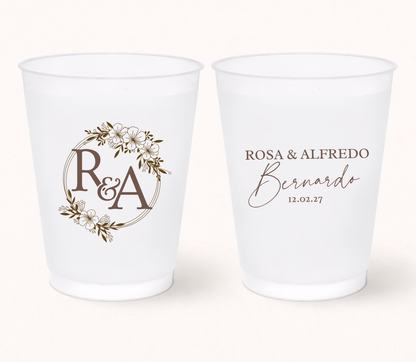Two white frosted cups with personalized designs on a white background