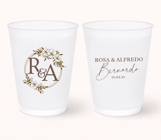 Two white frosted cups with personalized designs on a white background