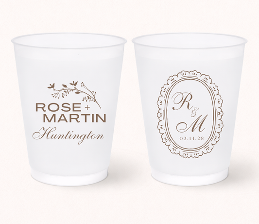 Two white frosted cups with personalized designs on a white background