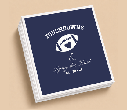Personalized Touchdowns & Tying The Knot football wedding napkins featuring a football heart design, navy blue background, and white wedding lettering.