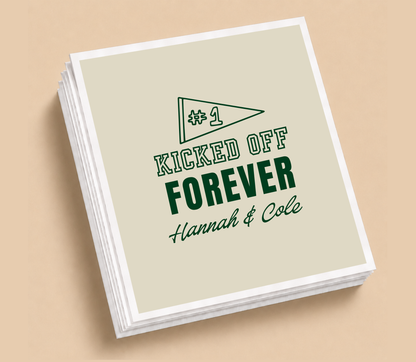 Personalized Kicked Off Forever football wedding napkins featuring a #1 football pennant, deep green lettering, neutral background, and custom couple names.