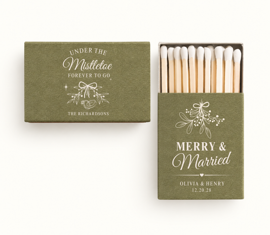 Personalized olive green Under The Mistletoe Christmas wedding matchboxes featuring white mistletoe artwork, Olivia and Henry names, and wedding date.