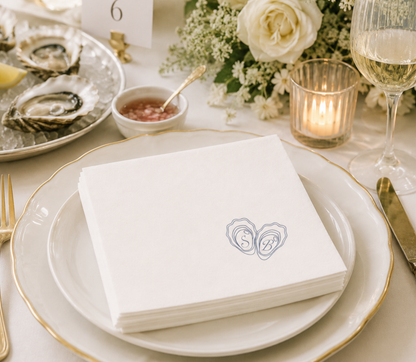 Elegant wedding table napkins with initials in the oyster shells on a napkin.