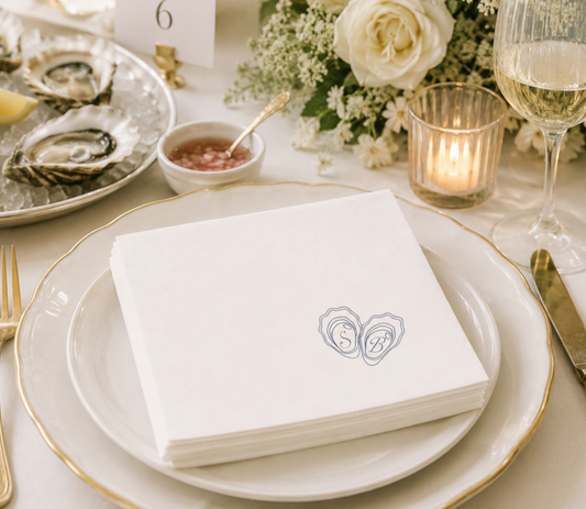Elegant wedding table napkins with initials in the oyster shells on a napkin.
