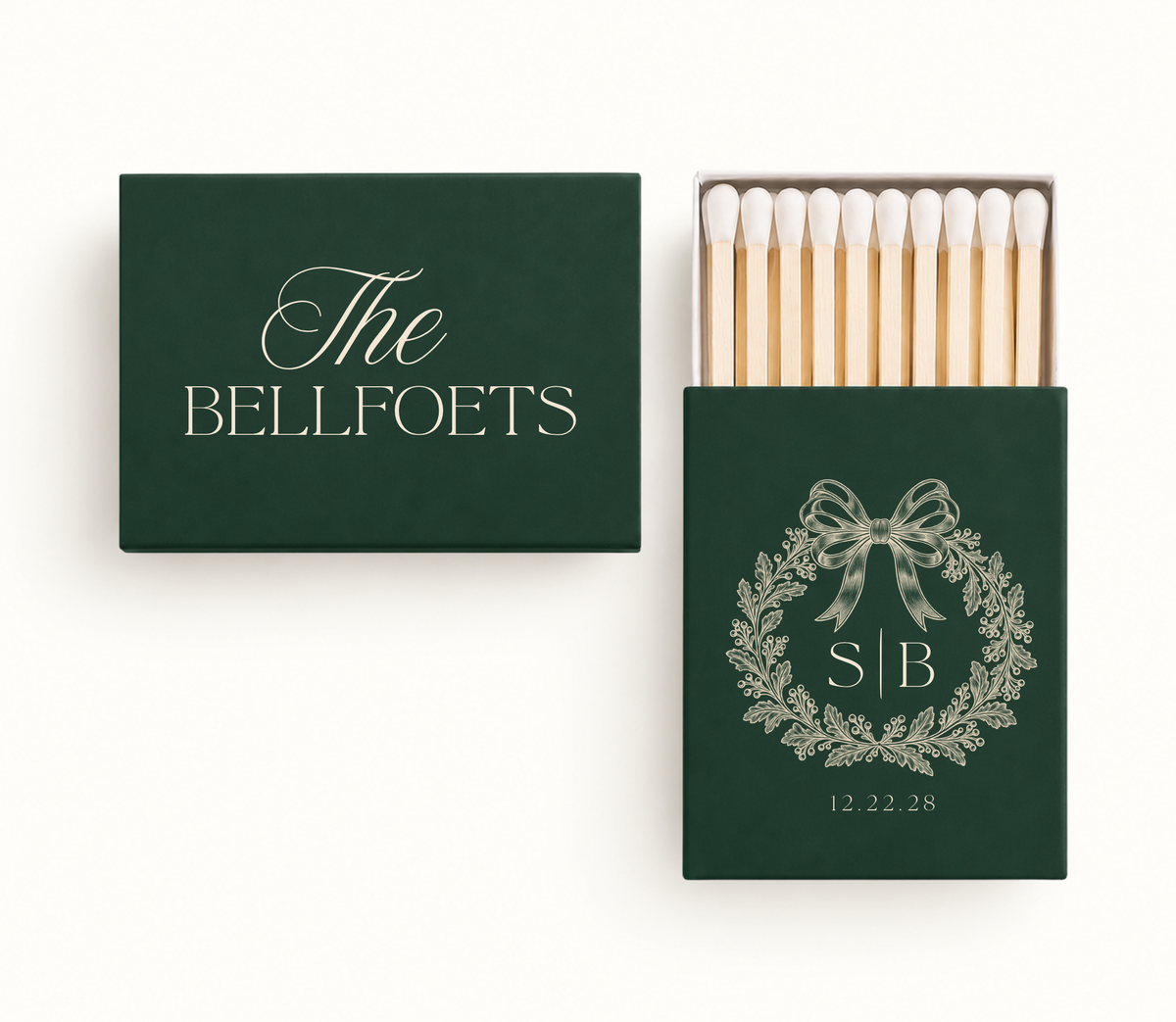 Personalized Christmas wedding matchboxes featuring deep green covers, cream botanical wreath artwork, custom family name, initials, and wedding date.