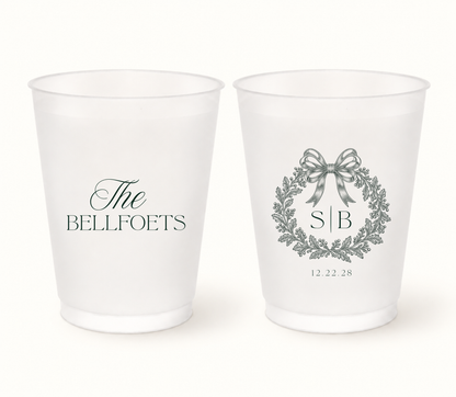 Personalized Christmas wedding frosted cups featuring an elegant bow wreath, custom initials, family name, and wedding date.