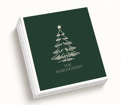 Personalized Christmas tree wedding napkins featuring a deep green background, cream Christmas tree, custom family name, and holiday wedding design.