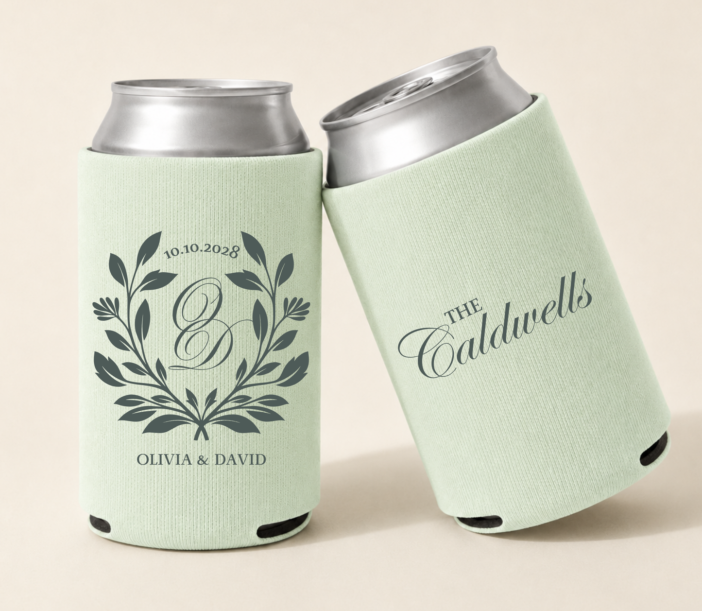 Light sage personalized wedding can coolers featuring a botanical laurel wreath, custom monogram B, Olivia and David names, wedding date, and The Caldwells family name.
