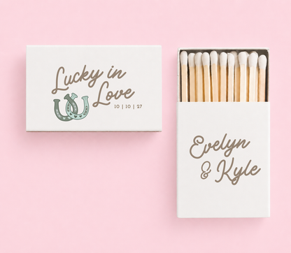 Personalized Lucky in Love wedding matchboxes with custom names, wedding date, and sage horseshoe artwork on white matchboxes