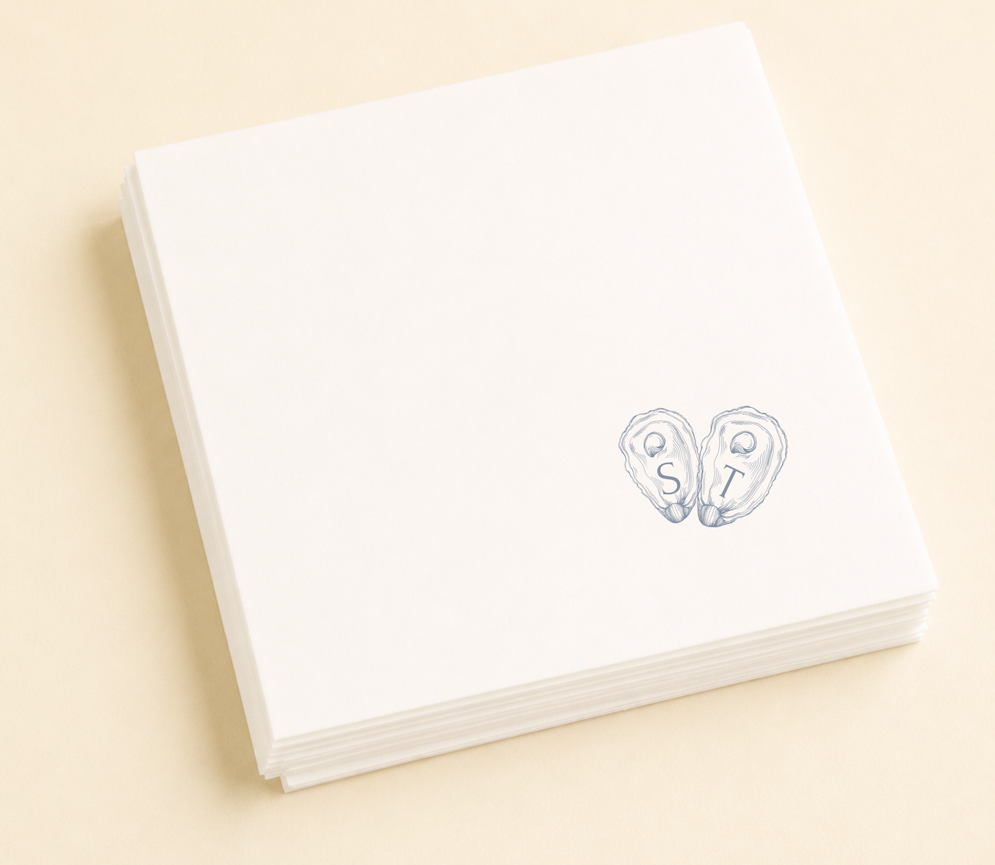 Personalized oyster wedding napkins with blue shell initials on white paper napkins for coastal wedding favors and table decor