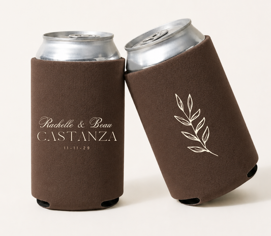 Personalized brown wedding can coolers featuring custom couple names, family name, wedding date, and elegant ivory botanical branch artwork.