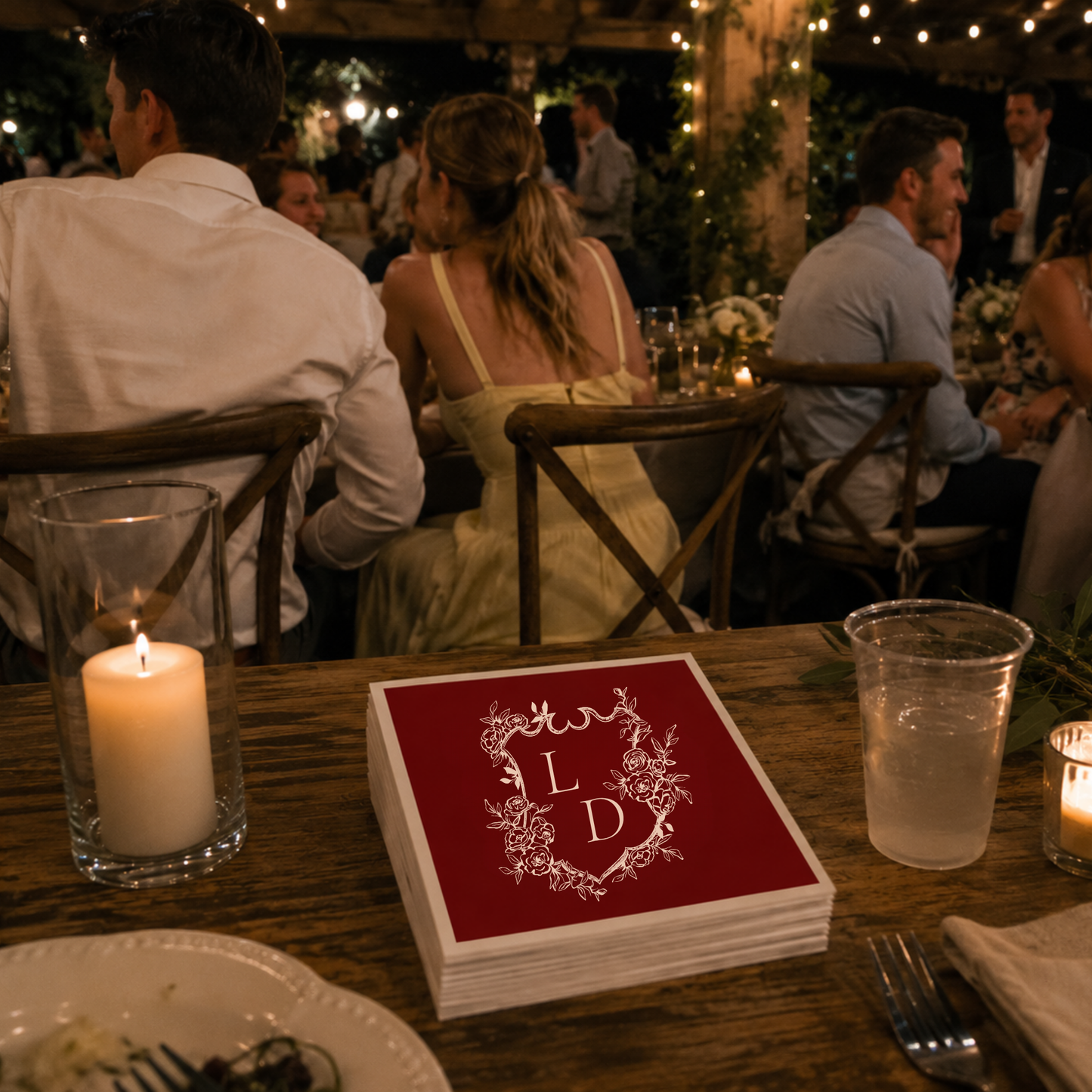 
Red wedding cocktail napkin featuring a floral crest monogram with personalized initials.
