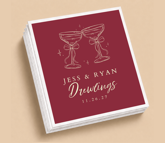 Personalized wedding table napkins featuring champagne glasses with bows, custom couple names, wedding date, and burgundy background.