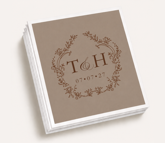 Personalized floral monogram wedding cocktail napkins featuring custom couple initials inside a botanical wreath with wedding date for elegant wedding receptions.