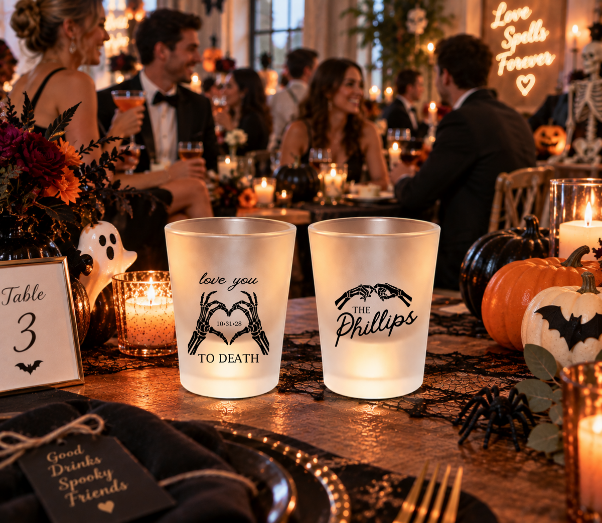Black and clear skeleton wedding shot glasses featuring Love You to Death wording and heart-shaped skeleton hand artwork.