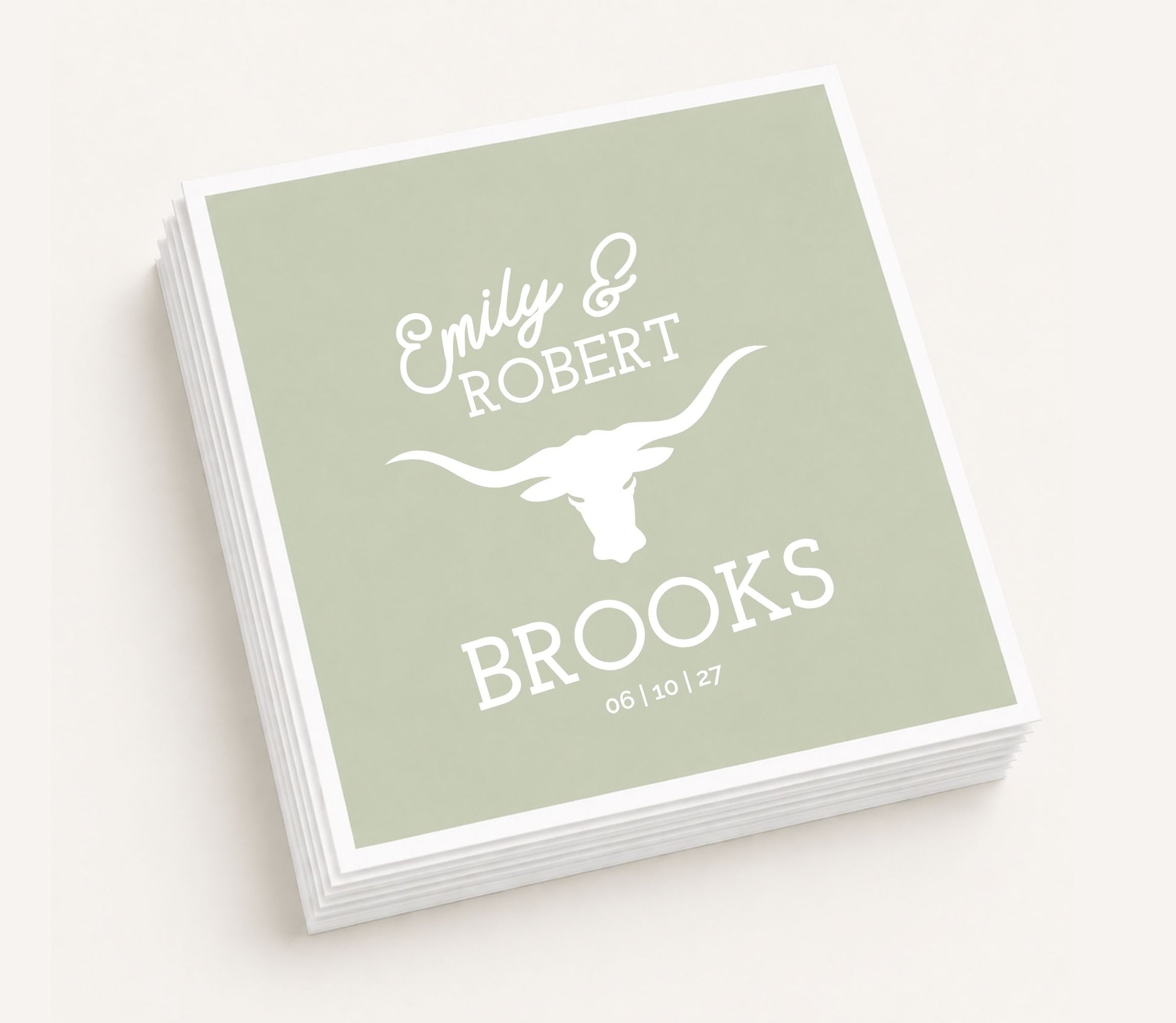 Sage green personalized wedding table napkin featuring custom couple names Emily and Robert Brooks, white longhorn graphic, wedding date, and premium paper construction.
Western wedding table napkin featuring a white longhorn design with personalized names.
Personalized ranch wedding table napkin with custom couple names and longhorn artwork.