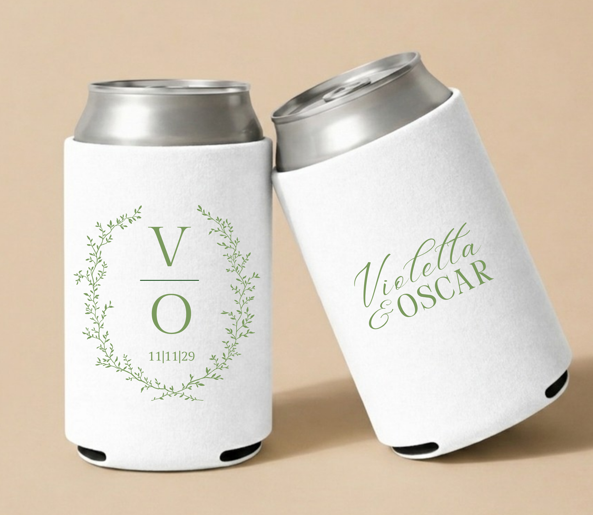 White personalized wedding can coolers featuring a botanical greenery wreath, custom initials V and O, wedding date, and personalized couple names Violetta and Oscar.