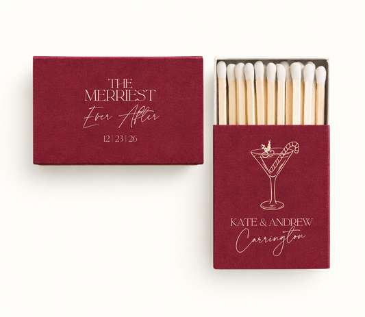 Personalized red The Merriest Ever After Christmas wedding matchboxes featuring holiday cocktail artwork, Kate and Andrew Carrington names, and wedding date.