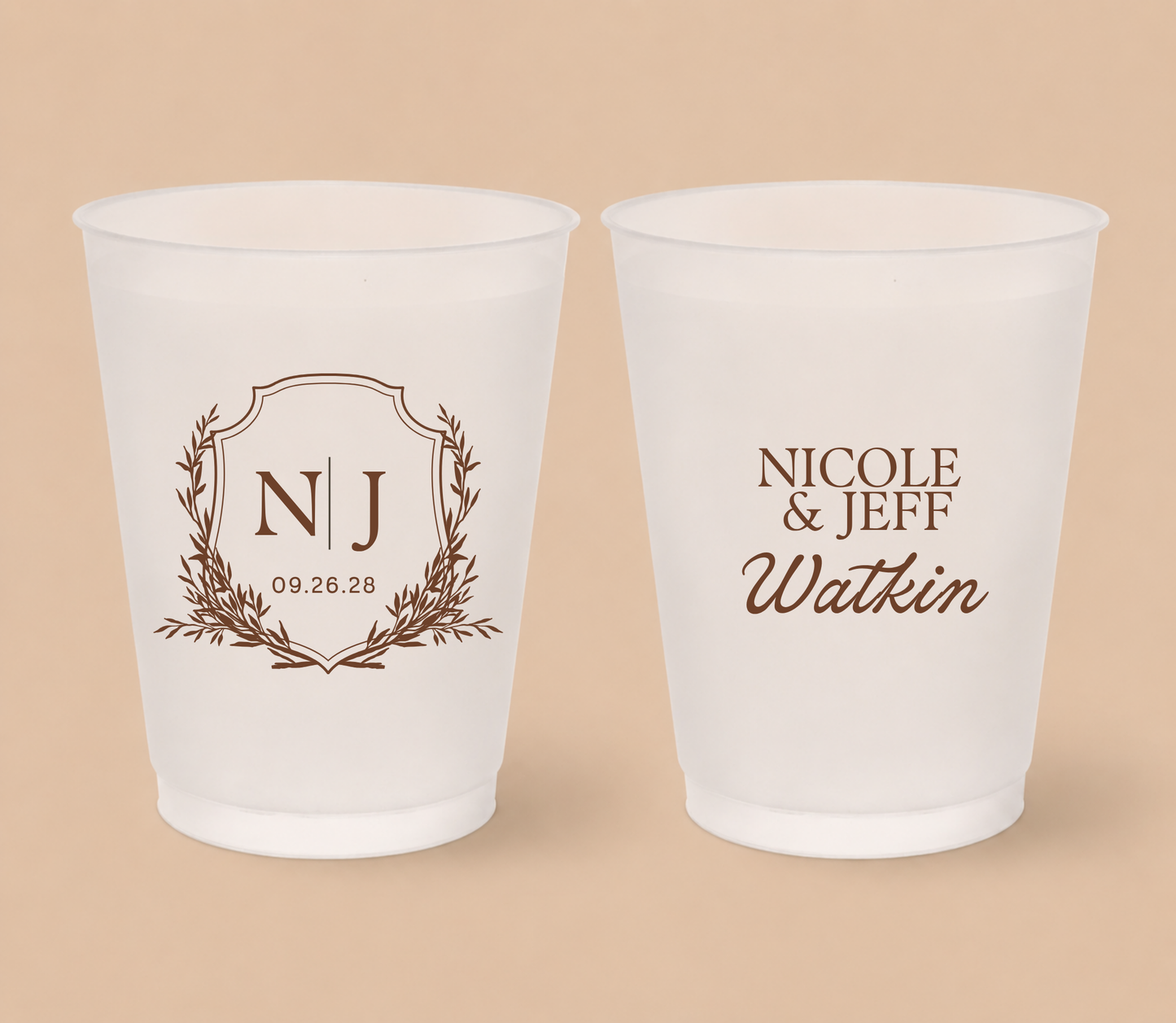 White frosted wedding cups featuring an elegant crest monogram with initials NJ, custom couple names Nicole and Jeff Watkin, and wedding date.