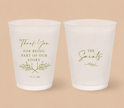 White frosted wedding cups featuring olive branch artwork, The Saints family surname, thank you message, and wedding date for a Mediterranean inspired wedding.