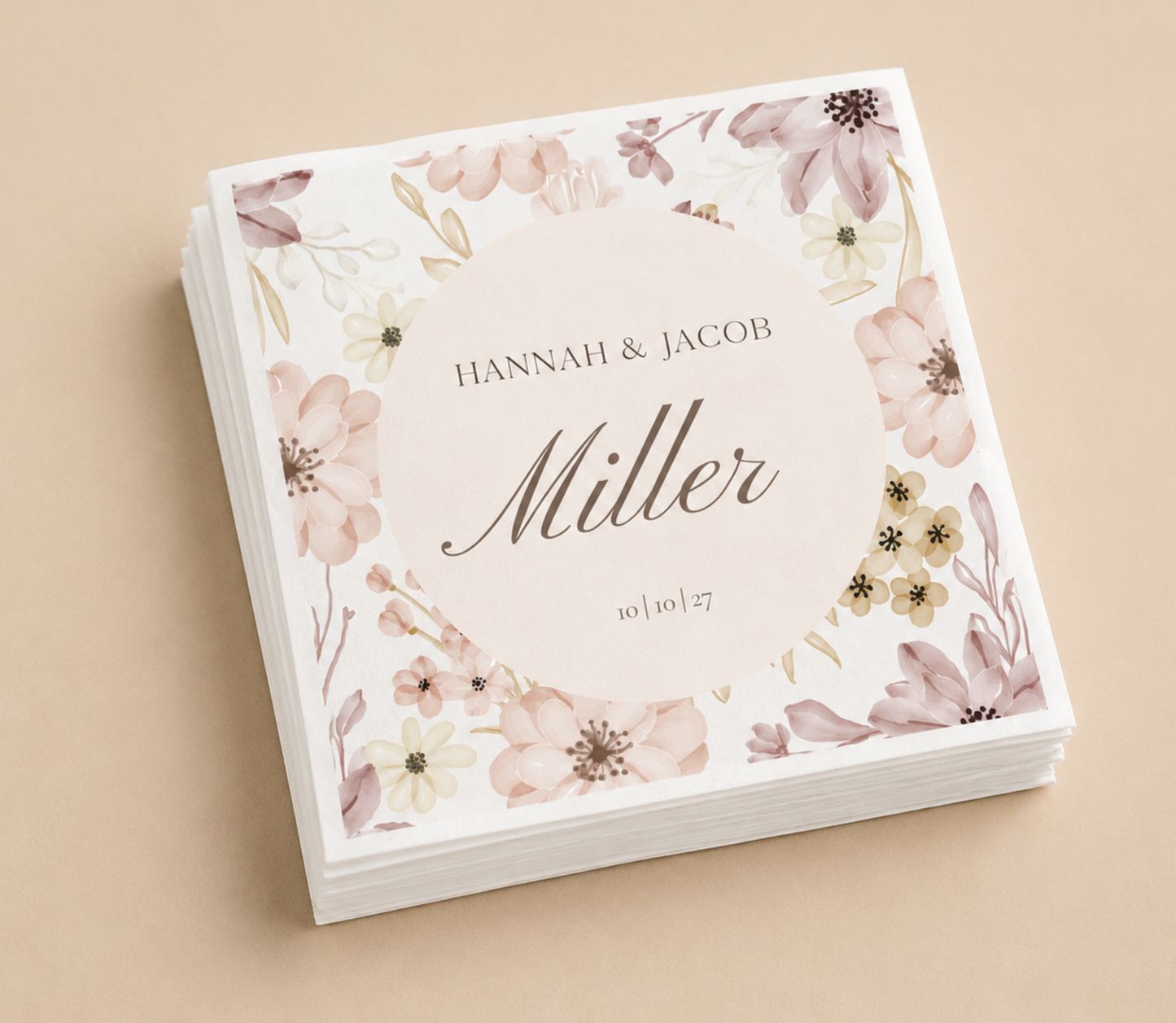 Personalized floral border wedding napkins with blush flower design, custom names, wedding date, and black script typography on white paper napkins