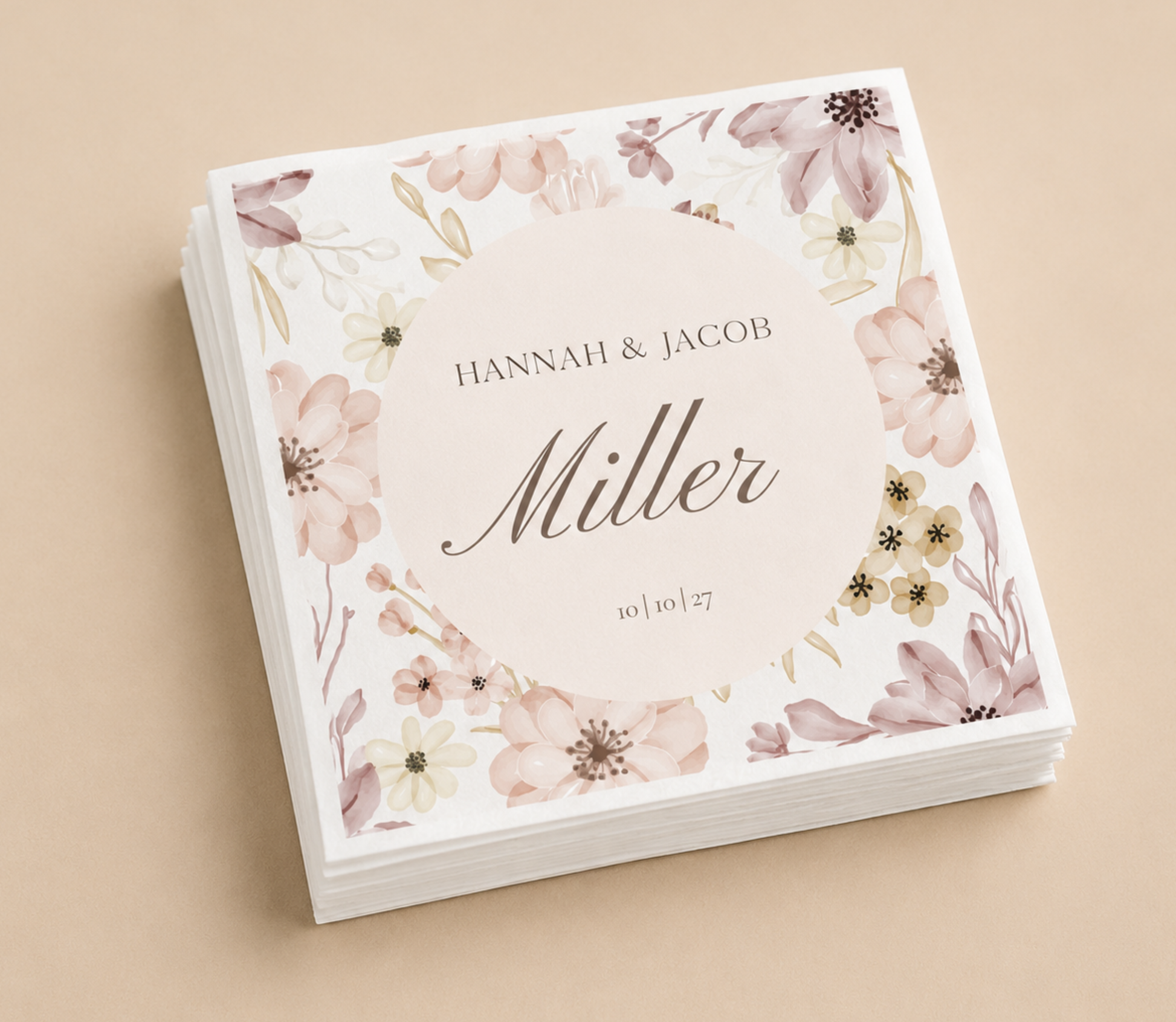 Personalized floral border wedding napkins with blush flower design, custom names, wedding date, and black script typography on white paper napkins