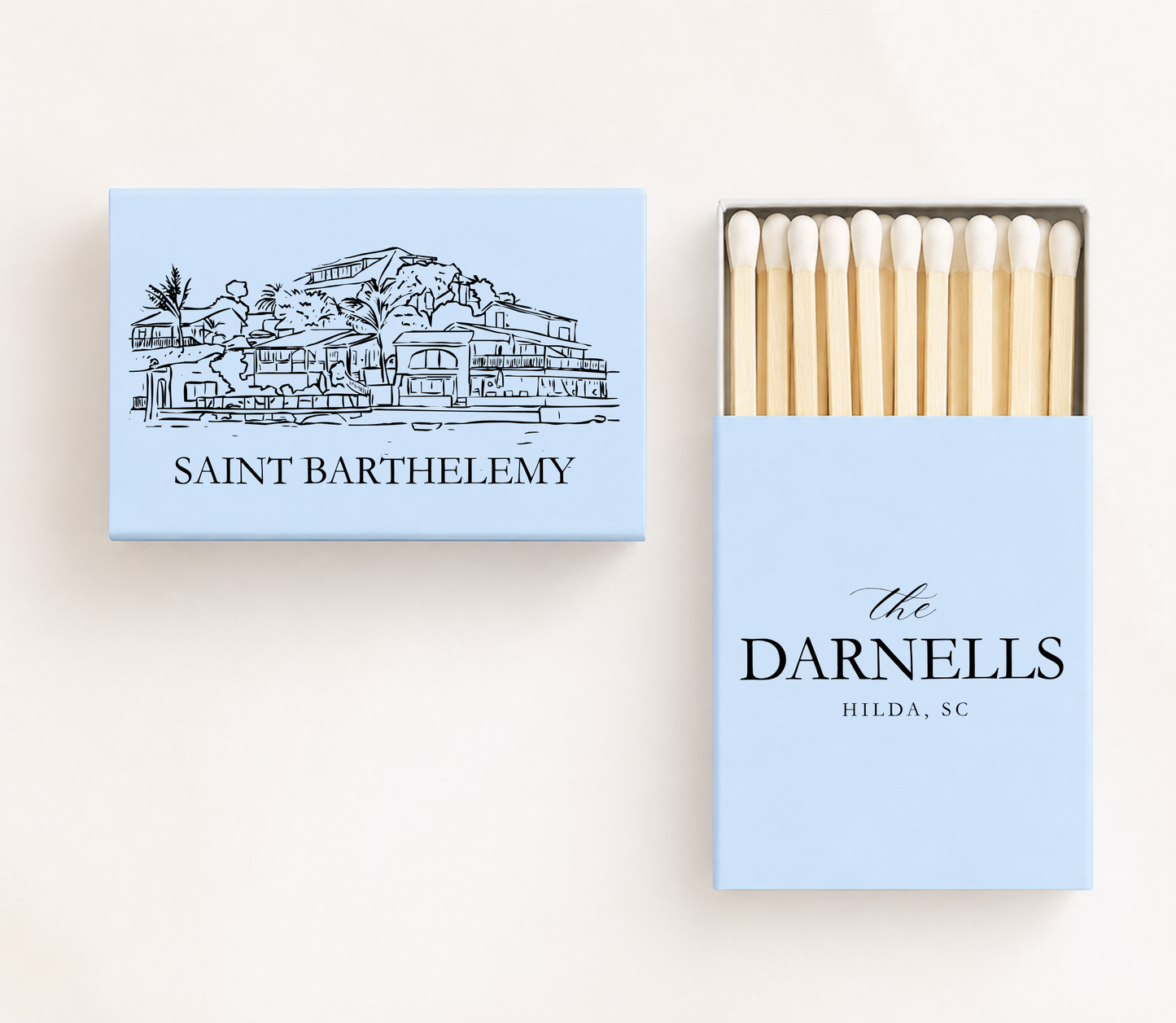 Personalized Saint Barthélemy wedding matchboxes featuring a St. Barts waterfront illustration with custom family name and wedding details.