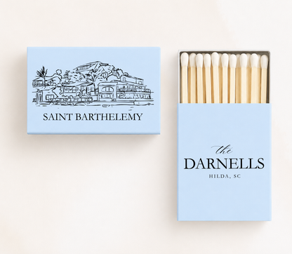 Personalized Saint Barthélemy wedding matchboxes featuring a St. Barts waterfront illustration with custom family name and wedding details.
