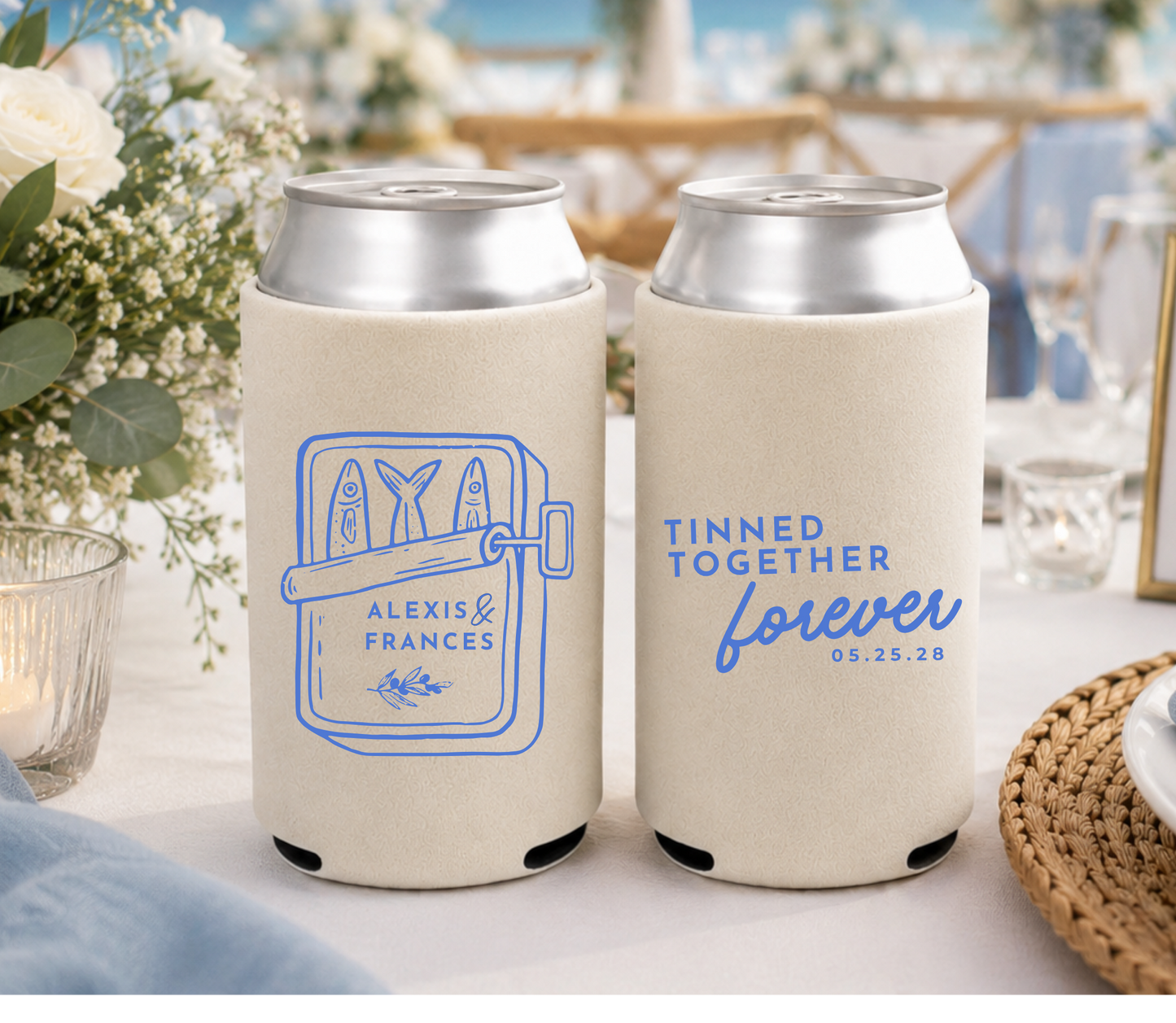 Two can coolers with personalized designs on a table with a wedding setting in the background.
