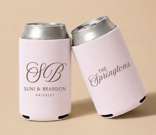 Pink personalized foam wedding can coolers featuring an ornate vintage monogram with initials SB family name The Springtons, and wedding date April 25, 2027.