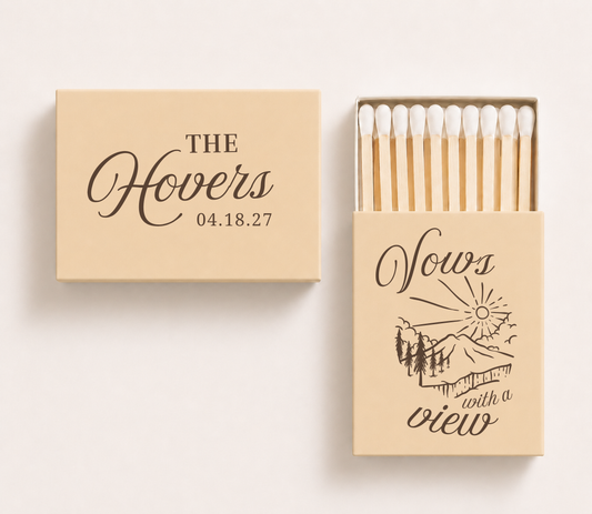 Personalized "Vows With A View" wedding matchboxes featuring custom family name, wedding date, and scenic mountain illustration for destination weddings.