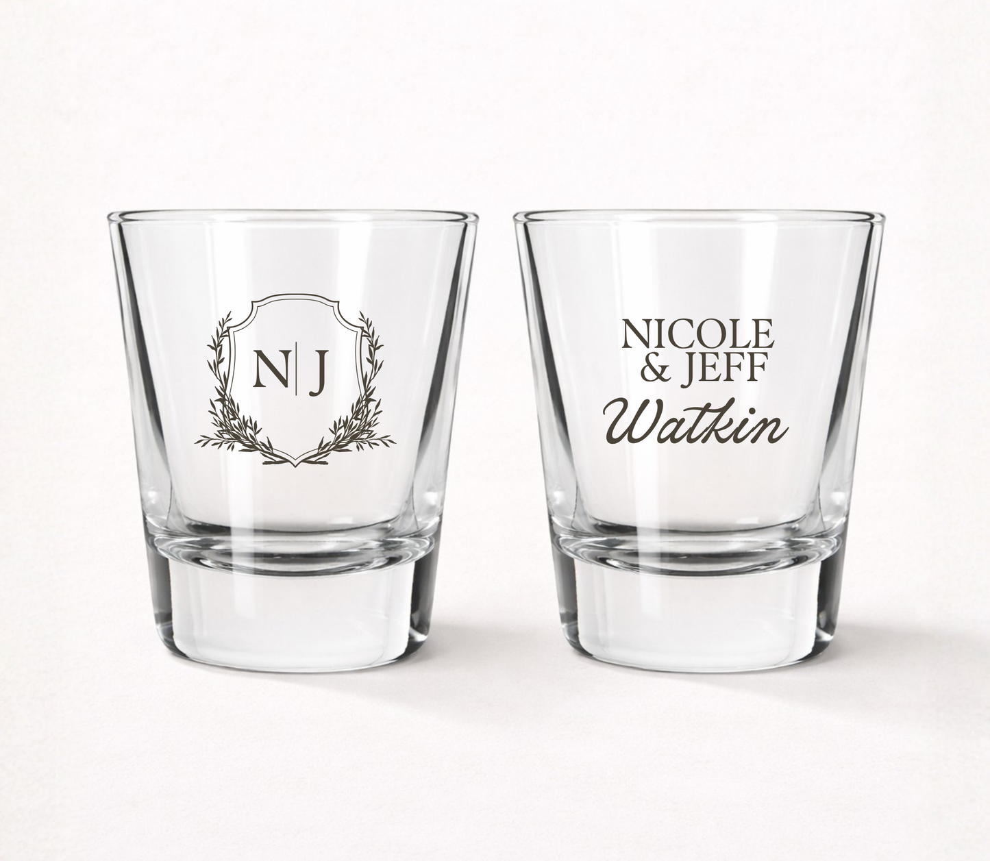 Personalized Watkin Monogram wedding shot glasses featuring custom initials, couple names, family name, and elegant botanical monogram crest.