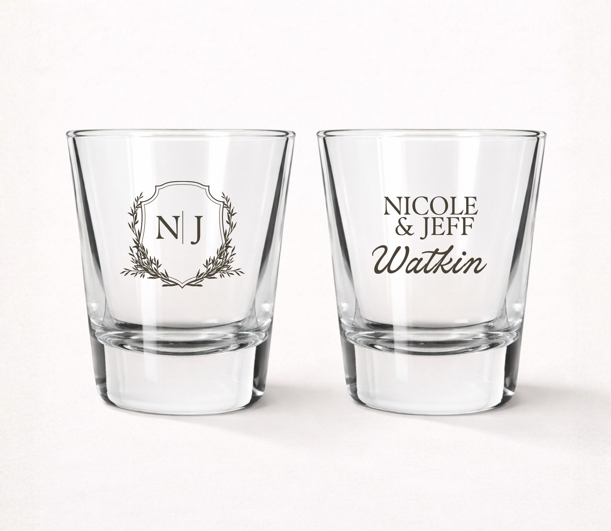 Personalized Watkin Monogram wedding shot glasses featuring custom initials, couple names, family name, and elegant botanical monogram crest.