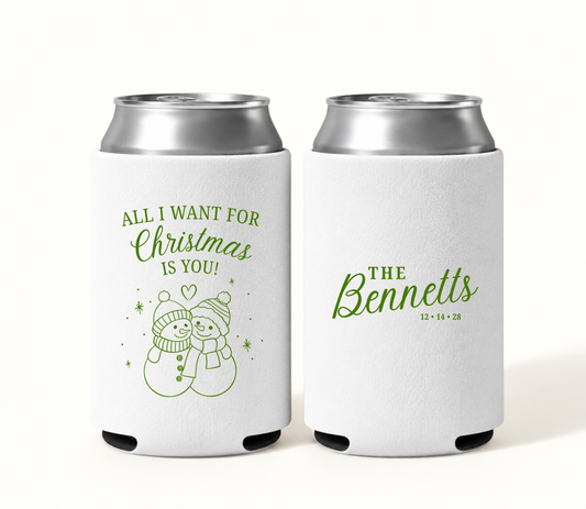 Personalized white All I Want for Christmas wedding can coolers featuring green snowman couple artwork, Bennett family surname, and wedding date 12.14.28.