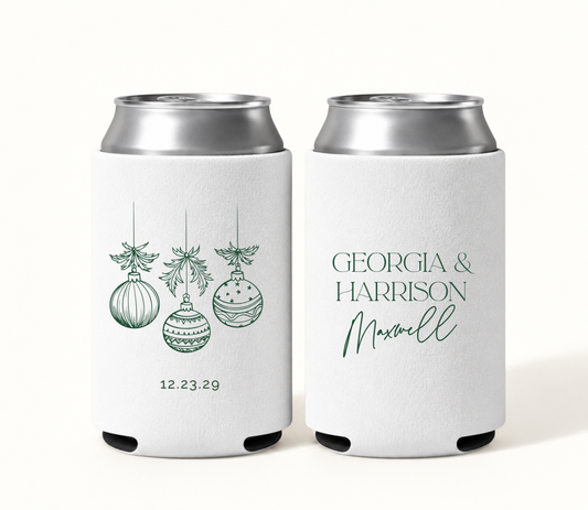 Personalized white Christmas wedding can coolers featuring green hanging ornament artwork, evergreen bow accents, wedding date, and Georgia and Harrison Maxwell names.