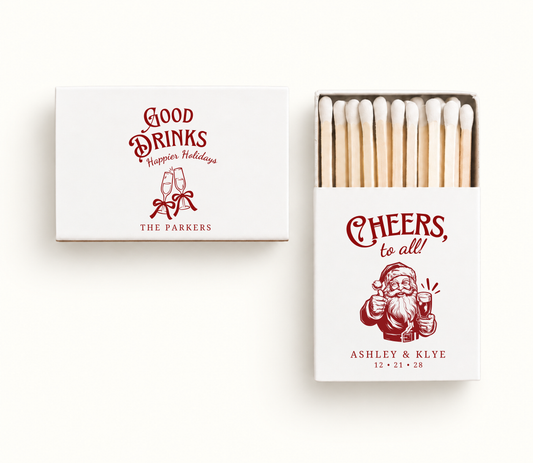 Personalized white Christmas wedding matchboxes featuring red champagne glass artwork, Santa illustration, couple names, and holiday wedding details.