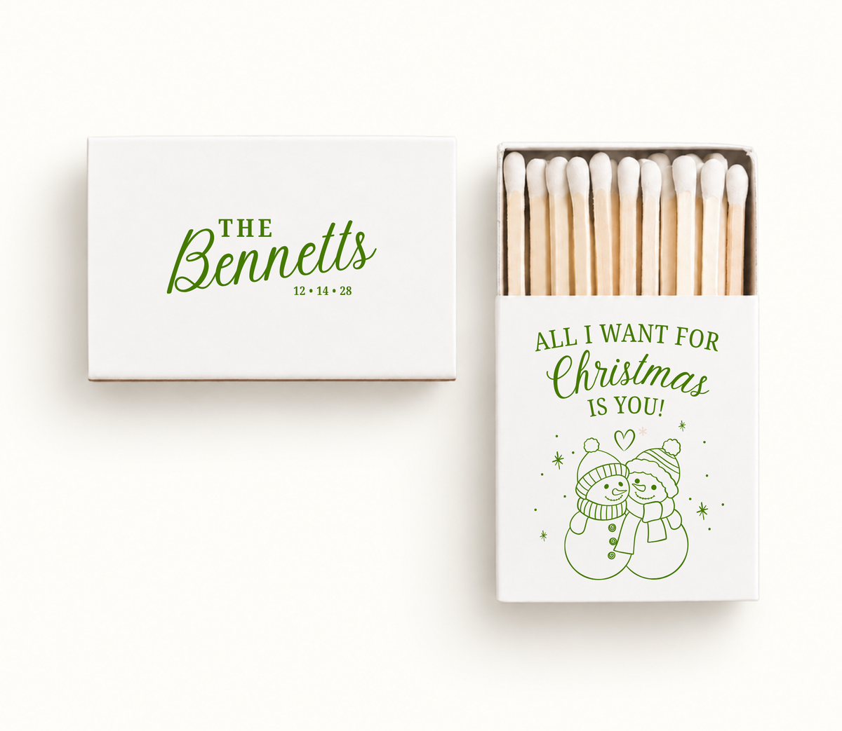 Personalized white All I Want for Christmas wedding matchboxes featuring green snowman couple artwork, The Bennetts name, and wedding date.