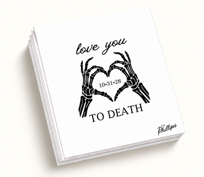 Personalized white Love You to Death wedding napkin featuring black skeleton hands forming a heart, wedding date 10.31.28, and The Phillips surname.