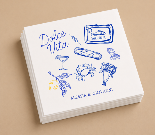 White personalized Dolce Vita wedding cocktail napkins featuring blue Italian-inspired illustrations and custom names Alessia and Giovanni.