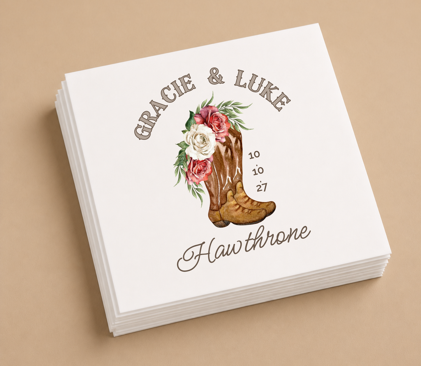 White personalized wedding cocktail napkin featuring floral cowboy boot artwork, custom names Gracie and Luke, family name Hawthorne, and wedding date.