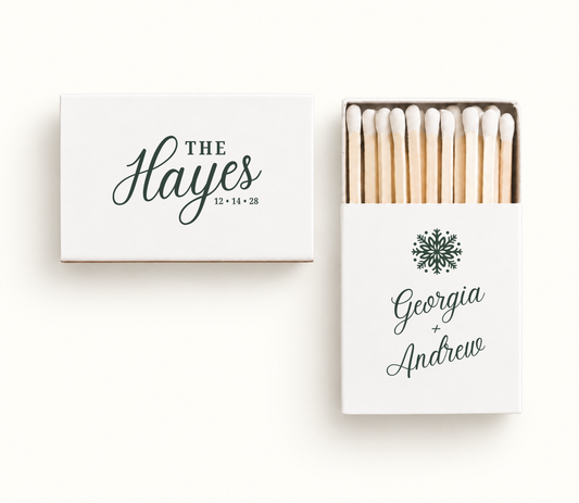 Personalized white Christmas wedding matchboxes featuring green snowflake artwork, The Hayes name design, Georgia and Andrew names, and wedding date.