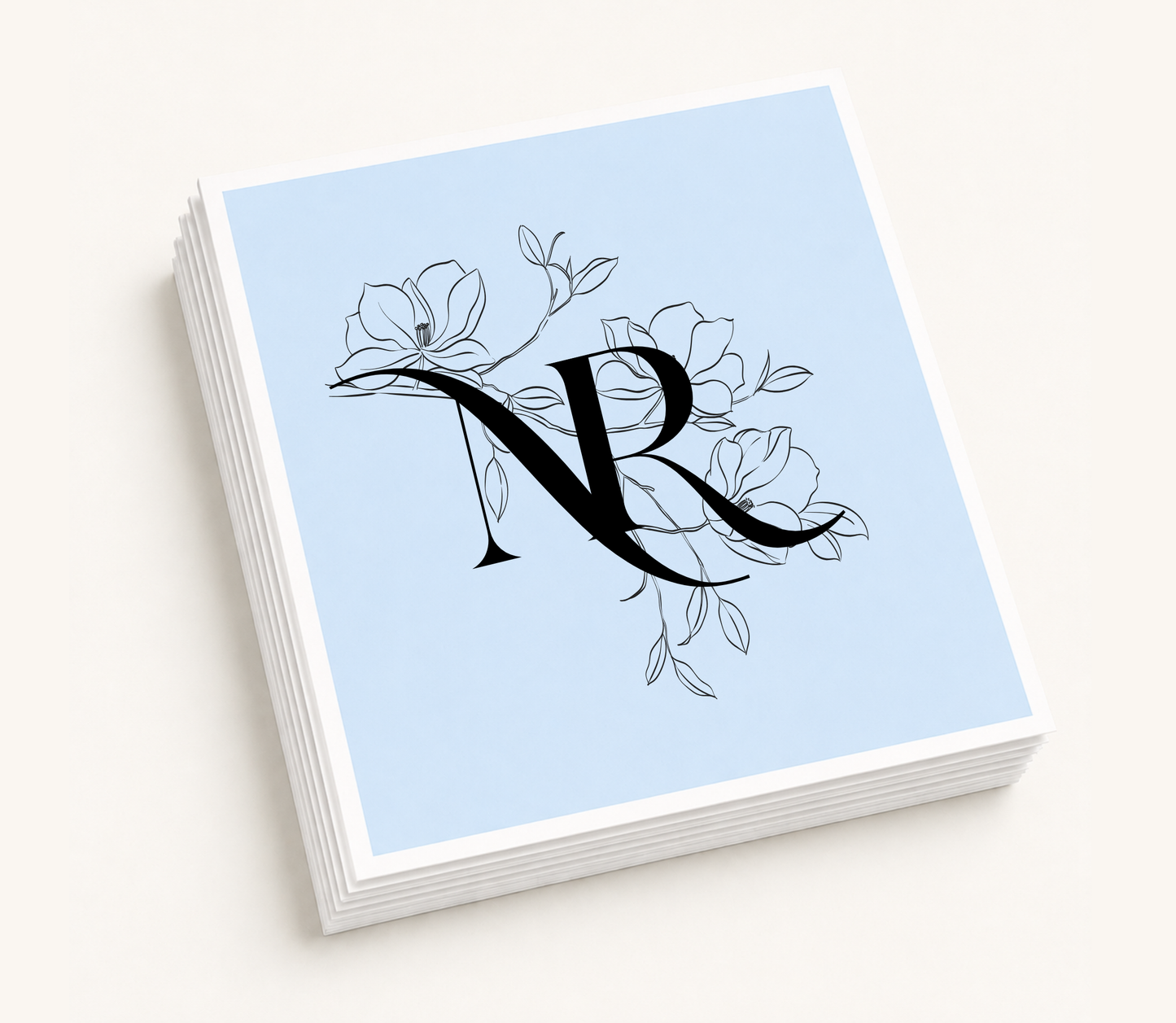 Personalized floral monogram wedding cocktail napkins featuring magnolia-inspired botanical artwork and custom intertwined initials.