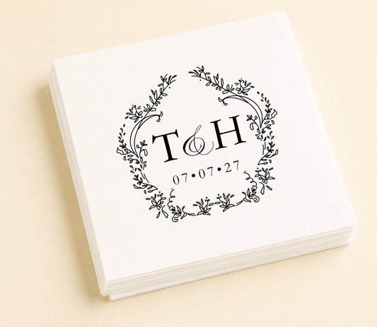 Personalized floral monogram wedding cocktail napkins featuring custom initials inside a delicate botanical wreath with wedding date.