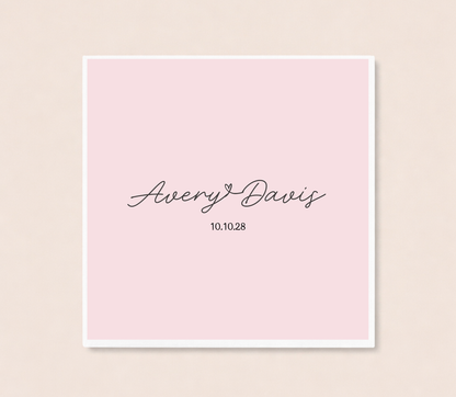 Personalized minimalist cocktail napkins featuring handwritten couple names connected by a heart and custom wedding date.