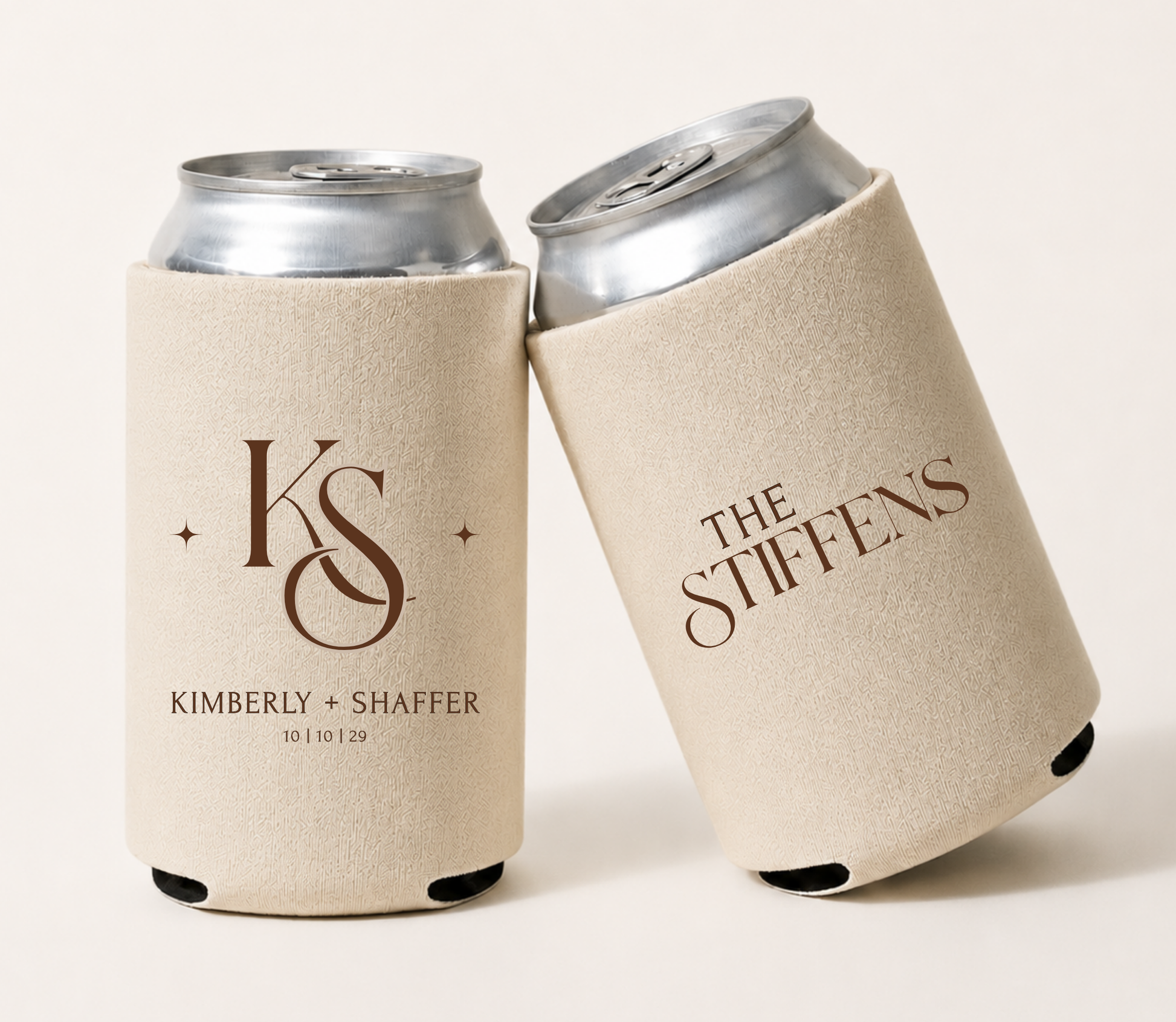 Cream personalized wedding can coolers featuring an elegant custom monogram, couple names, family name, and wedding date in a minimalist design.